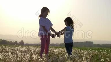 两姐妹手牵着手在郊外城市公园的蒲公英空地上盘旋。自由无忧无虑。